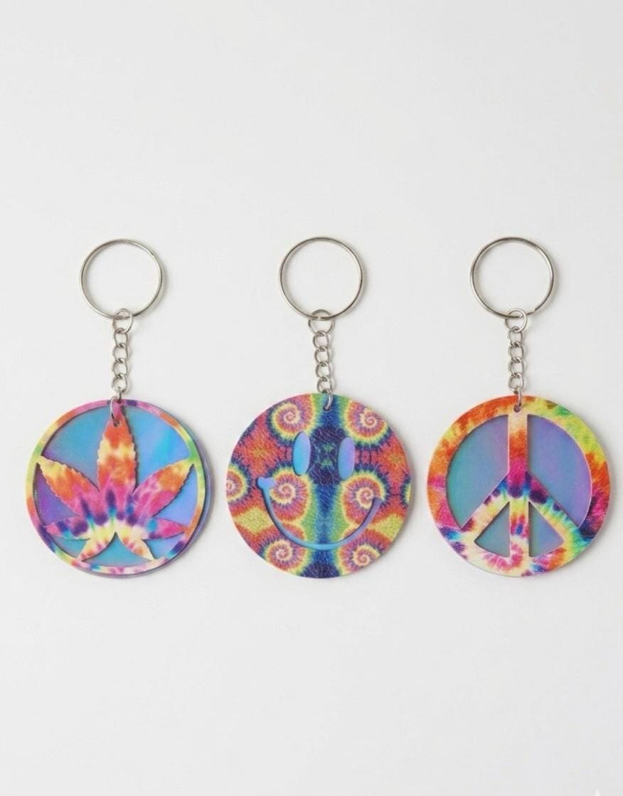 Three colorful keychains with tie-dye patterns on a white background