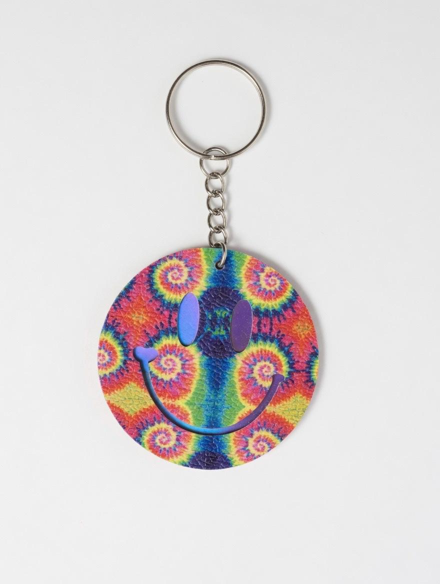 Colorful tie-dye smiley face keychain on a white background